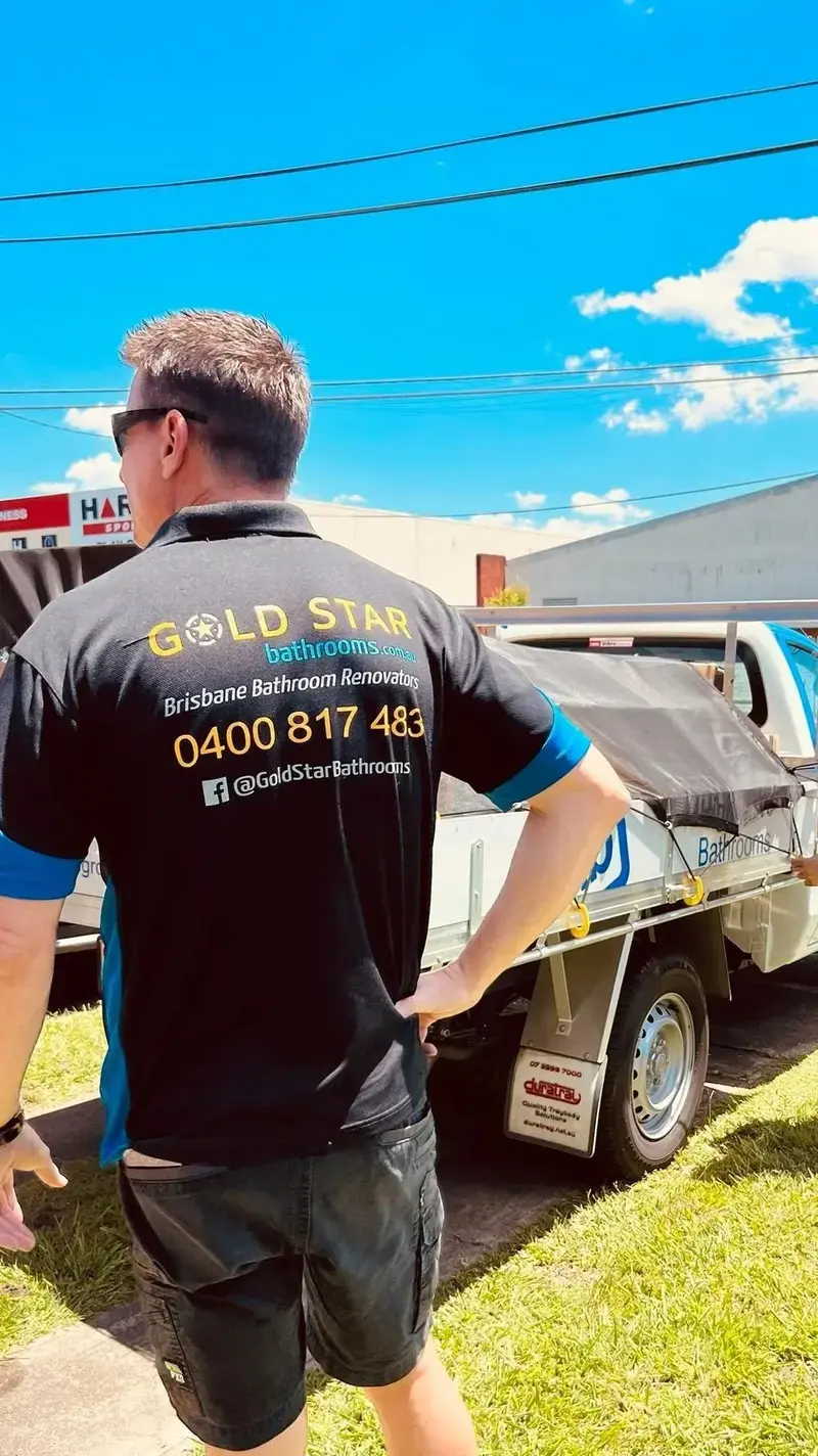 Shannon Vane in a Gold Star Bathrooms shirt beside the work ute